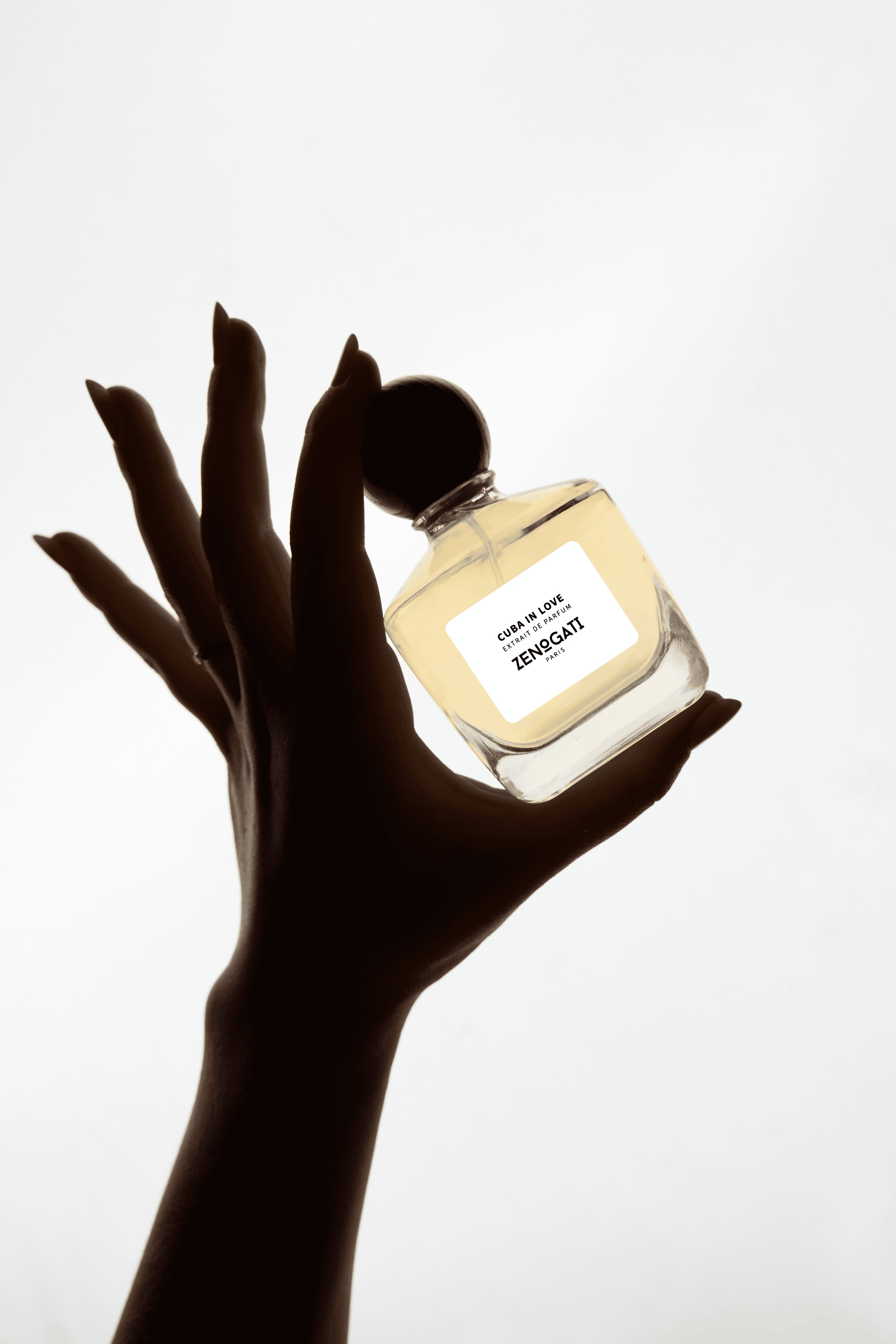 Flacon Zenogati Cuba in Love tenu en main en silhouette sur fond clair