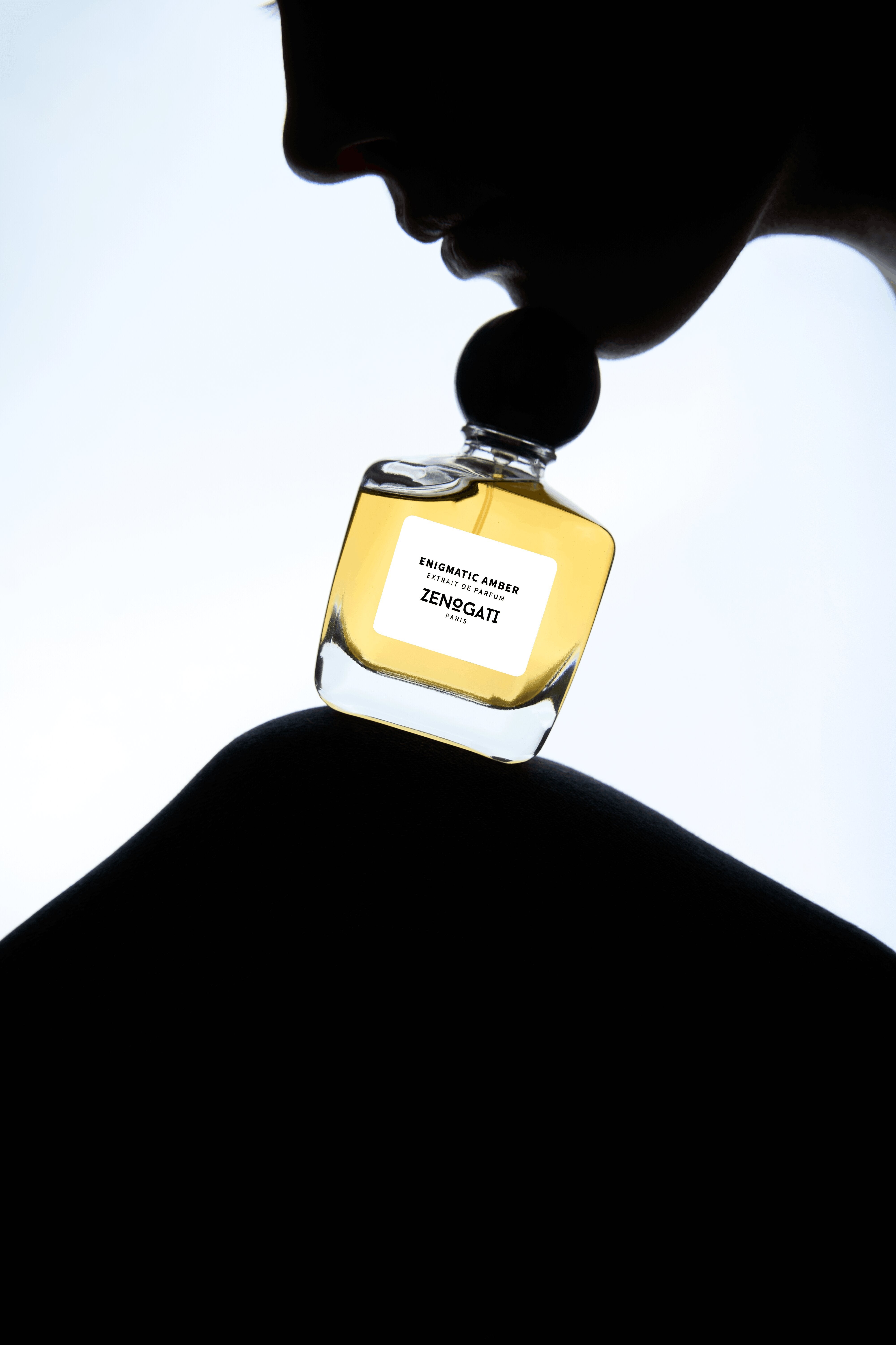 Flacon Zenogati Enigmatic Amber près d’un profil en silhouette, fond clair